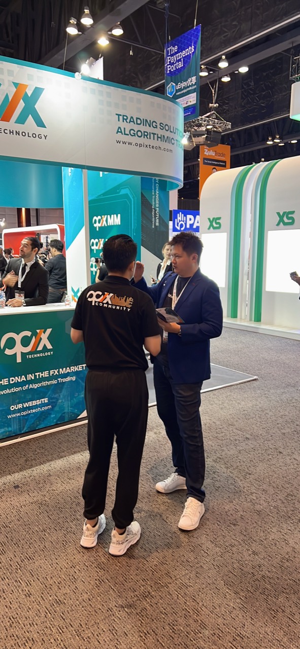 Lucas Loo speaking with a contact at a fintech exhibition booth