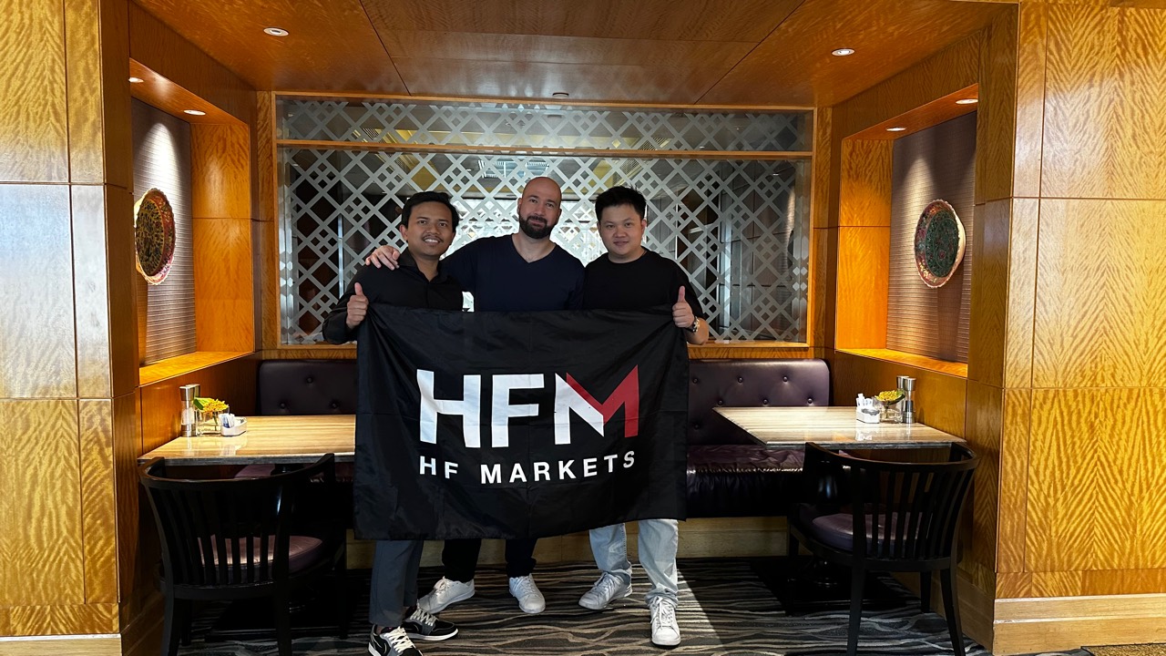 Lucas Loo with partners holding HFM banner