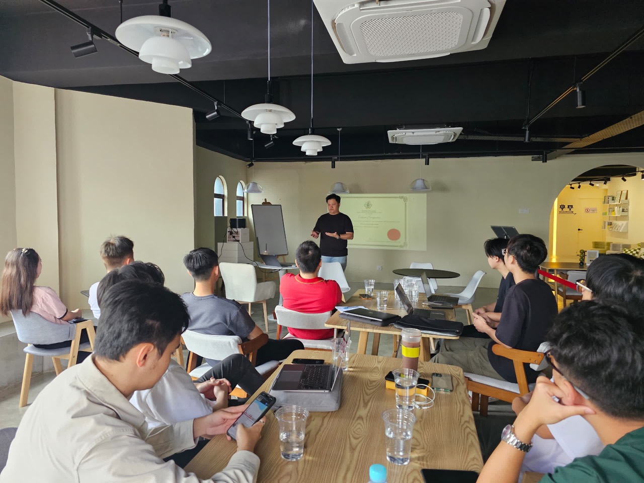 Lucas Loo presenting to a small learning room